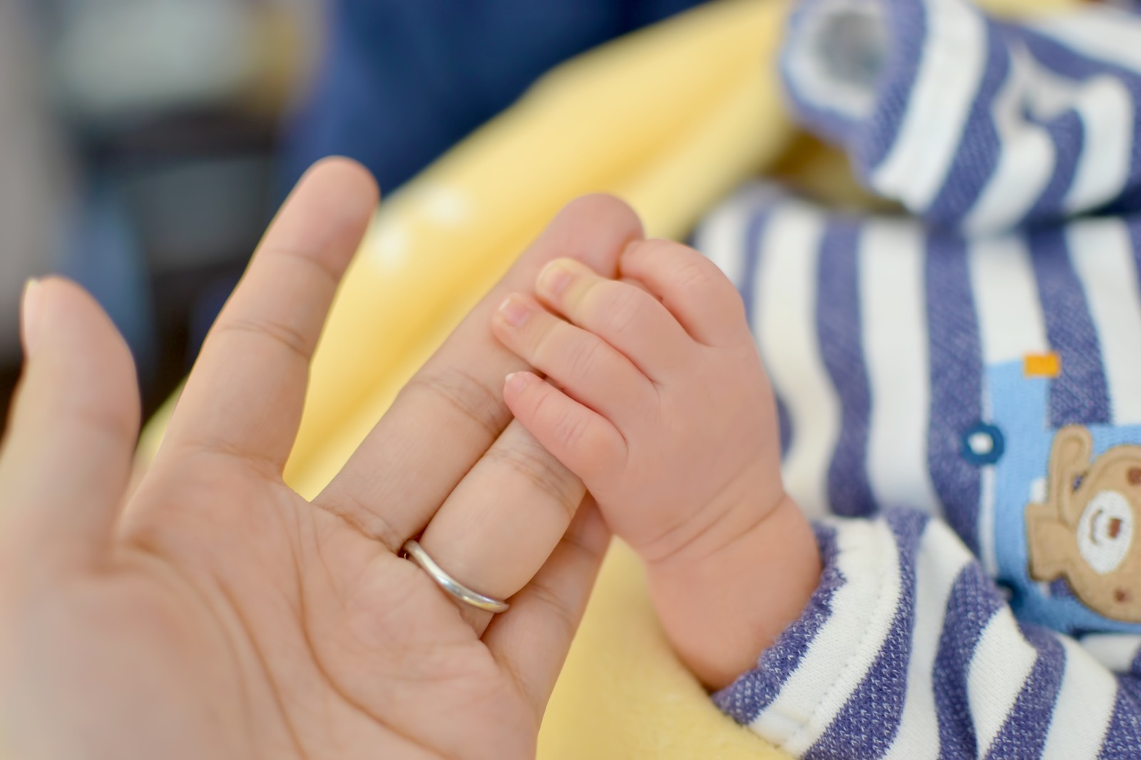 母親の指を握る赤ちゃんの手（イメージ）